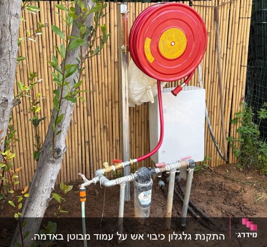 גלגלת כיבוי אש מותקנת ליד גדר במבוק